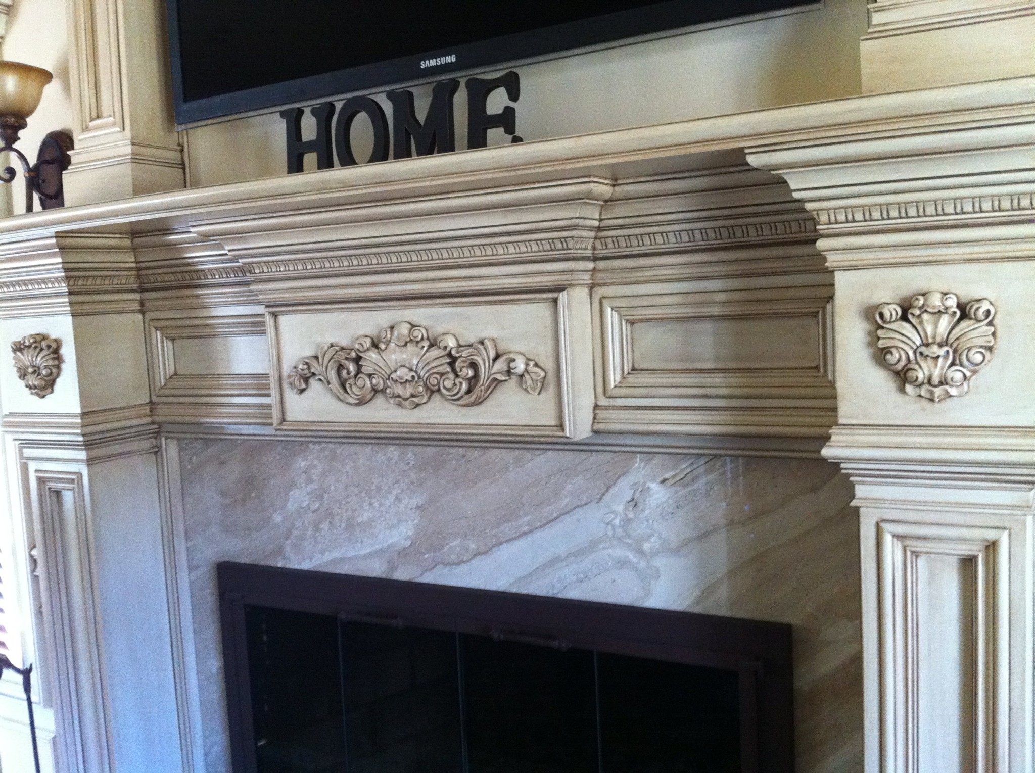 Fireplace mantel and trim with off-white paint and antiquing glaze.