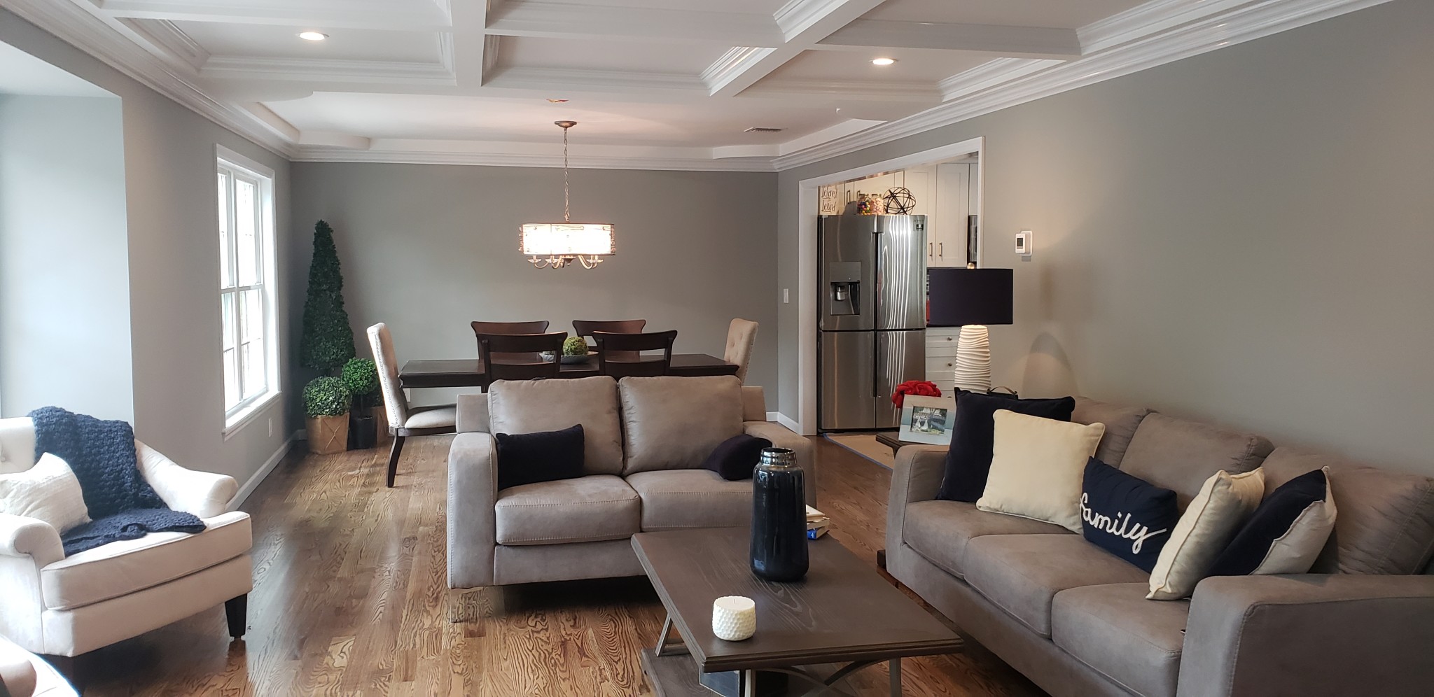 White painted coffered ceiling and crown moldings with light gray walls.